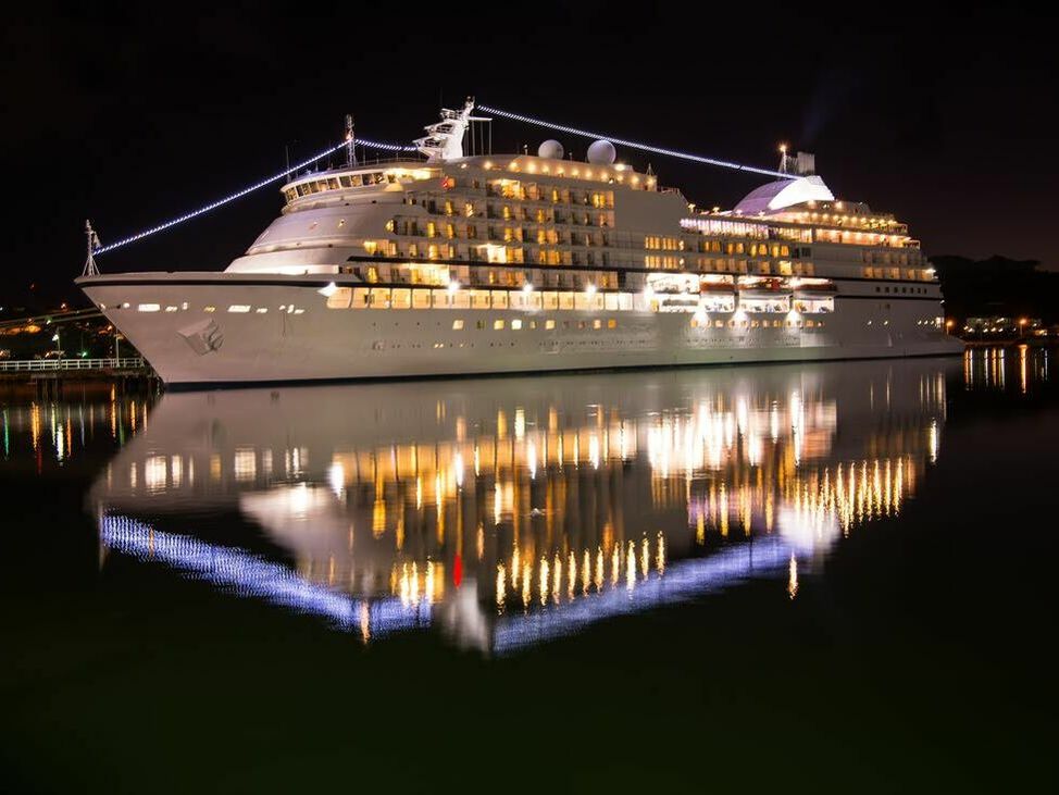 Large luxury cruise ship on sea water at night with illuminated light docked at port of st.Johns, Antigua